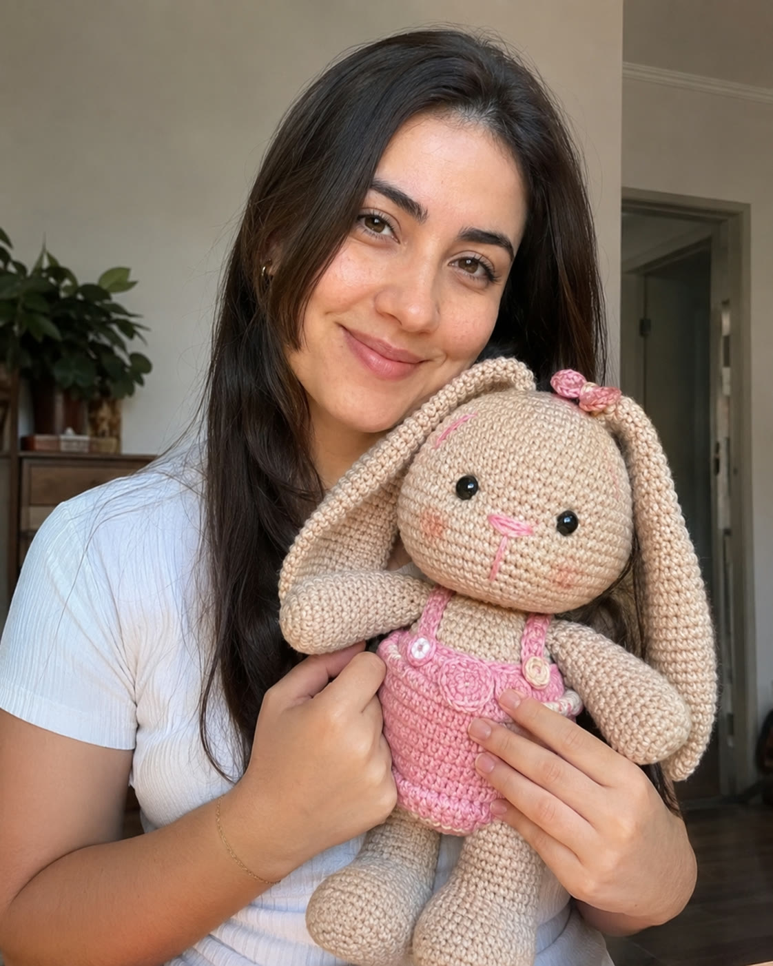 Clienta sosteniendo una conejita de crochet hecha por ella.
